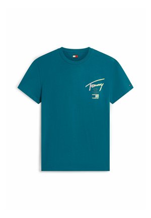 T-shirt bleu sarcelle à manches courtes et col rond avec un petit lettrage « Tommy » et des noms de villes imprimés sur la poitrine gauche, ainsi qu'un petit drapeau sur la manche gauche.