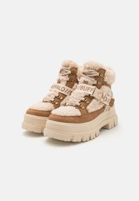 Chunky ankle boots with beige faux shearling and brown suede. Features metal hardware, lace-up design, and a thick textured sole.