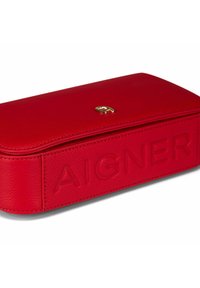 Étui en cuir rouge avec logo embossé "AIGNER", forme rectangulaire, texture lisse, et logo accent doré sur le dessus.