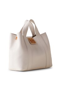 Beige Leder-Tote mit strukturierter Form, ausgestattet mit doppelten Griffen und einem goldenen Dekorationsschild auf der Vorderseite. Glatte Textur mit Nahtdetails.