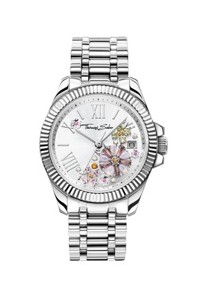 Silberne Armbanduhr mit floralen Kristalldekorationen, römischen Ziffern als Stundenmarkierungen, Datumsanzeige und Thomas Sabo-Logo auf weißem Zifferblatt mit Metallarmband.