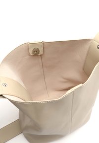 Borsa a secchiello in pelle beige con una texture liscia, design minimale e una sola tracolla; presenta una chiusura a pressione e una fodera interna morbida.