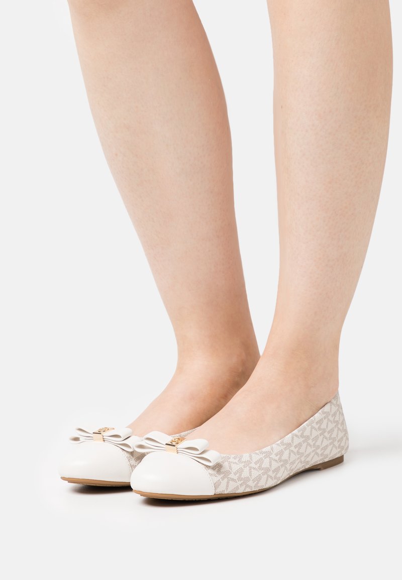 Balerinák fehér bőrből készült orral, bézs mintás szövet felsőrésszel, masni díszítéssel az orrán és alacsony profilú kialakítással.