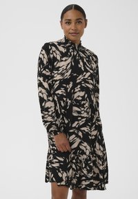 Must ja beež kleit pikkade varrukatega, voldiliste servadega kõrge kaelusega ja lilleliste abstraktsete mustritega. Laienev seelik kihilise disainiga. Tekstuurne kangas.