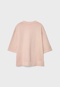 Übergroßer blassrosa kurzärmeliger Sweatshirt mit geripptem Rundhalsausschnitt und Saum, dargestellt vor einem schlichten hellgrauen Hintergrund.