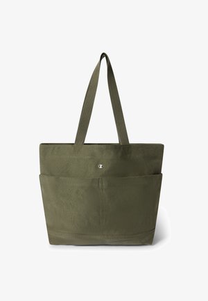 Sac fourre-tout vert olive avec deux longues anses, grande poche avant et petit logo métallique centré près du bord supérieur.