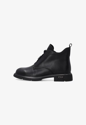 Schwarze Leder-Stiefeletten verfügen über ein schlankes Design, eine abgerundete Zehenpartie, einen seitlichen Reißverschluss und eine profilierte Sohle für besseren Halt. Akzentuiert mit einem Logo an der Ferse.
