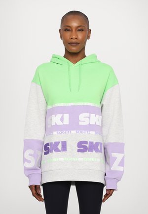Hettegenser i grønn, grå og lavendel med stor "SKI" tekst. Har en avslappet passform og teksturerte stoffs detaljer.