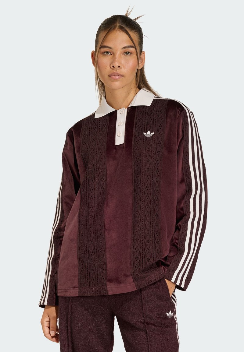 Bordeaux velours langemouwen top met een witte kraag, drie knopen placket en witte strepen op de mouwen. Heeft een gestructureerd verticaal patroon.