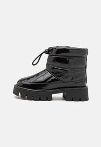 Black patent leather ankle boot with a padded upper, round toe, elastic drawstring, and chunky rubber sole with a ridged pattern.