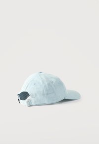 Ανοιχτό μπλε καπέλο μπέιζμπολ από τζιν, εμφανιζόμενο από πίσω, με ρυθμιζόμενο λουράκι και μεταλλικό κούμπωμα, σε απλό λευκό φόντο.