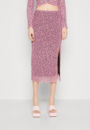 Lyserød blomstertrykt gennemsigtig maxi-nederdel med en sideslids, bølget kant og lagdelt design, parret med lyserøde chunky platform sko.