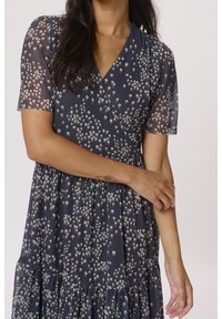 Navy mit Blumenmuster, kurzes, durchscheinendes Ärmelschnitt und V-Ausschnitt, mit geschichteten Stufen und leichtem Stoff.