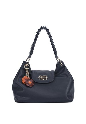Borsa a mano in pelle nera con tracolla intrecciata, chiusura a patta con logo metallico e portachiavi con due ciondoli a forma di fiore nei colori marrone e arancione.