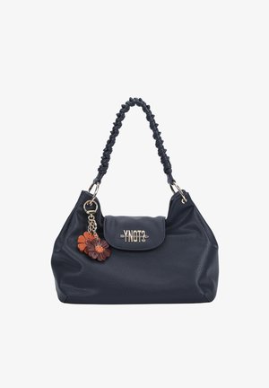 Borsa a mano in pelle nera con tracolla intrecciata, chiusura a patta con logo metallico e portachiavi con due ciondoli a forma di fiore nei colori marrone e arancione.