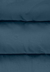 Tessuto testurizzato di un blu profondo, con una superficie leggermente stropicciata e pieghe orizzontali. Finitura morbida e opaca. Nessun motivo o accento distintivo.