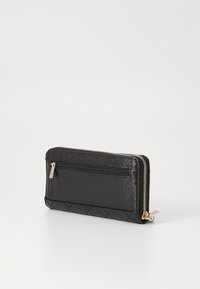 Portafoglio zip nero realizzato in materiale sintetico texturizzato con un'esterno decorato. Presenta una cerniera liscia e una tasca posteriore per riporre gli oggetti.
