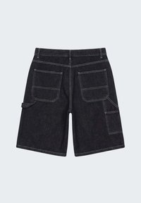 Short en denim noir avec des coutures doubles, deux poches arrière, une boucle latérale à gauche et une poche plaquée sur la jambe droite.