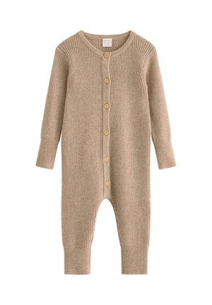 Beżowy kombinezon z prążkowania, z długimi rękawami, zapięciem na guziki i ściągaczami przy kostkach. Wykonany z miękkiego materiału o teksturowanym wykończeniu.