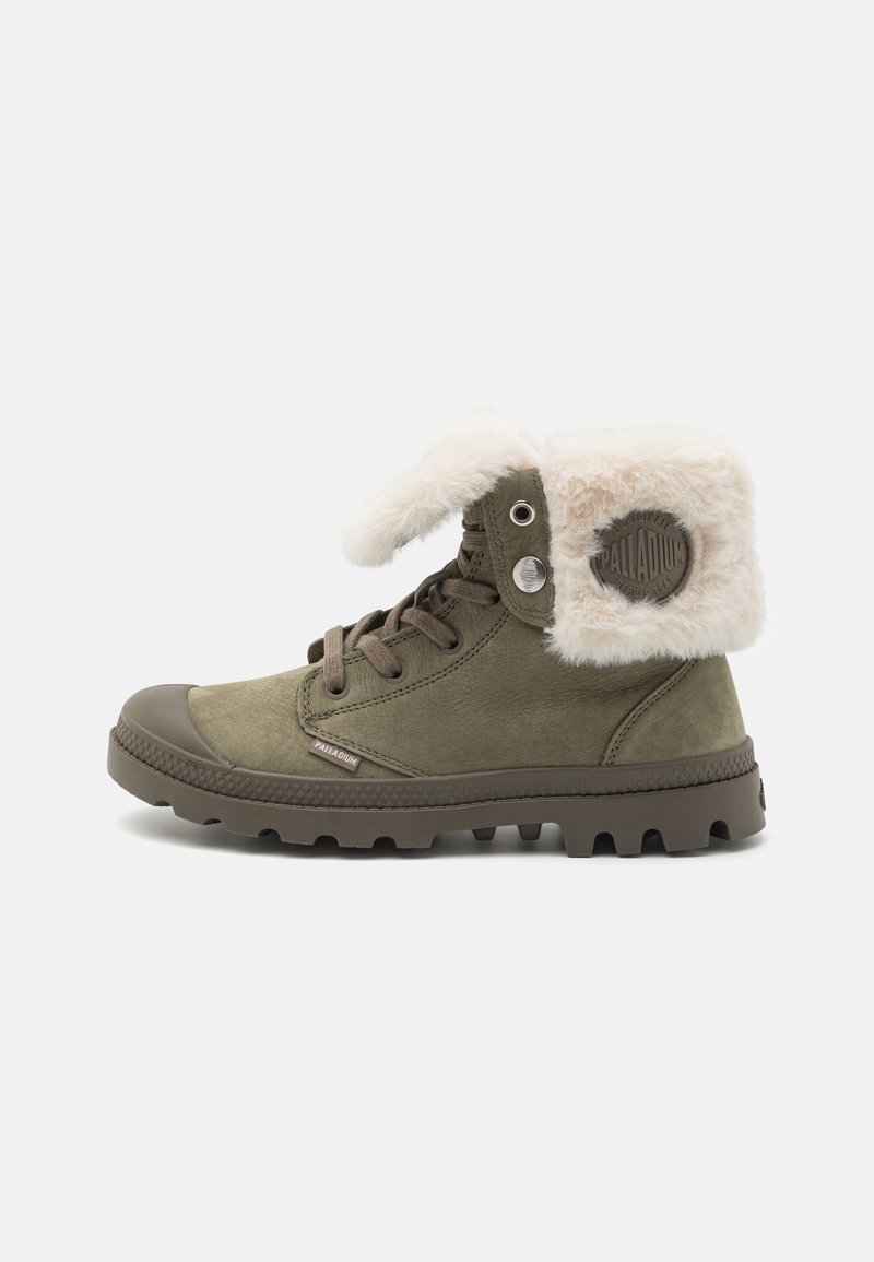 Botte vert olive à lacets avec semelle en caoutchouc épaisse et revers en fourrure blanche pliée, affichant le logo Palladium sur le côté et la languette.