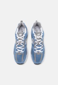 Blaue und graue Laufschuhe aus Mesh- und Synthetikmaterialien, mit runder Zehenpartie, weißen Schnürsenkeln und einem gepolsterten Kragen. Auffälliges Logo auf der Zunge.