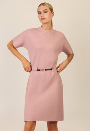 Knielanges, rosa gestricktes Kleid mit hohem Kragen, kurzen Ärmeln und einem schwarzen Gürtel mit goldener Akzentuierung in der Taille.
