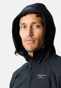 Zwarte hoodie gemaakt van synthetisch materiaal met een rits, voorzien van een logo op de borst en een textuur binnenzijde van de capuchon.