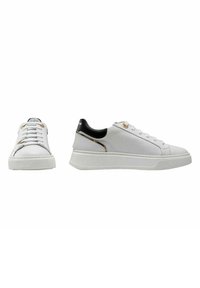 Zapatillas de cuero blancas con ribetes negros, suela de goma plana, ojales de metal y un patrón texturizado en el talón. Presenta un diseño minimalista.