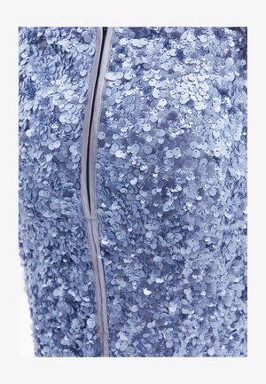 Blauer Paillettestoff mit runden, reflektierenden Pailletten; verfügt über einen glatten Reißverschluss entlang der Naht. Die Textur ist glänzend und strukturiert.