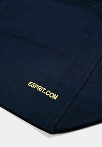 Tote en tissu marine avec une surface texturée ; présente une broderie dorée "ESPRIT.COM" dans le coin inférieur, accentuée par des coutures épurées.