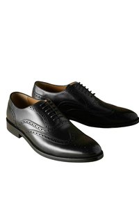 Pantofi negri din piele cu vârful rotund, detalii decorative de tip brogue și închidere cu șireturi. Finisaj neted cu o ușoară strălucire.