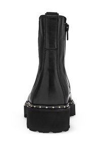 Bottine en cuir noir avec un talon chunky, fermeture éclair sur le côté et détails en clous métalliques le long de la semelle. Texture lisse et design épuré.