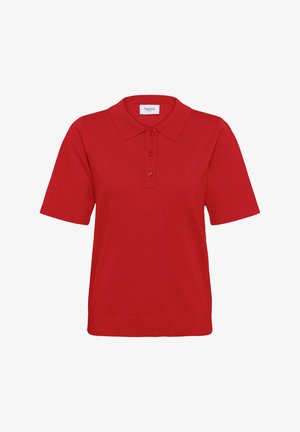 Rotes Poloshirt mit gerippter Textur, kurzen Ärmeln, dreiknopfiger Blende und klassischem Kragen. Das Etikett trägt die Aufschrift "Saint."