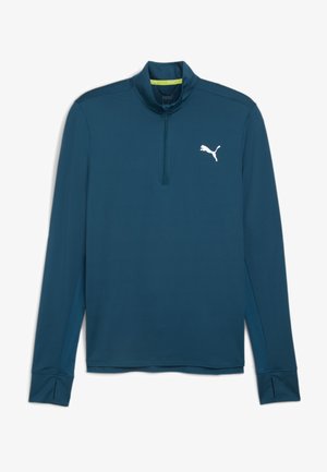 Długi rękaw, turkusowy sweter z ćwierć zamkiem, z białym logo Puma na klatce piersiowej i teksturowanymi akcentami materiałowymi po bokach.