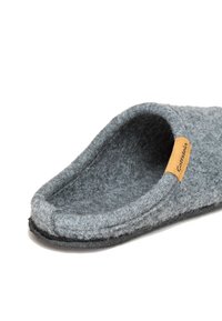 Gray felt slipper with an open design, featuring a soft texture, a curved top, and a brown label at the side. Black rubber sole.