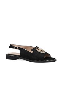 Zwarte suède slingback schoen met open teen, voorzien van een decoratieve gouden ketting en parelaccent. Plat zool met contrasterende stiknaad.