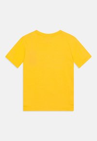 Camiseta de algodón amarilla de manga corta, con cuello redondo y textura suave, sin patrones ni logotipos visibles.