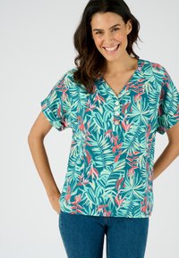 Blusa de manga corta en verde con un patrón floral tropical, con escote en V y tres botones en la parte delantera. Material de algodón.