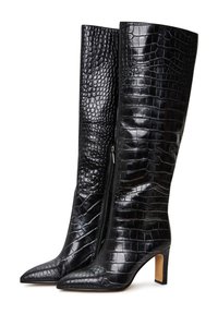 Botas negras hasta la rodilla, hechas de cuero con estampado de cocodrilo brillante, con puntera puntiaguda y un tacón cuadrado de 3 pulgadas. Presenta un cierre de cremallera en el costado.