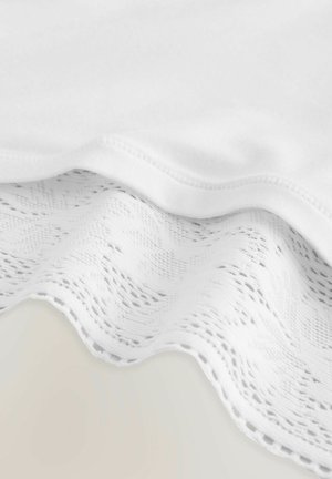 White fabric featuring a textured lace edge with a wavy pattern, contrasted with a smooth inner layer, showcasing a delicate design.