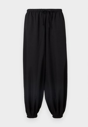 Pantalons noirs amples avec une taille élastique et un cordon de serrage. Poignets ajustés aux chevilles. Tissu doux et texture lisse.
