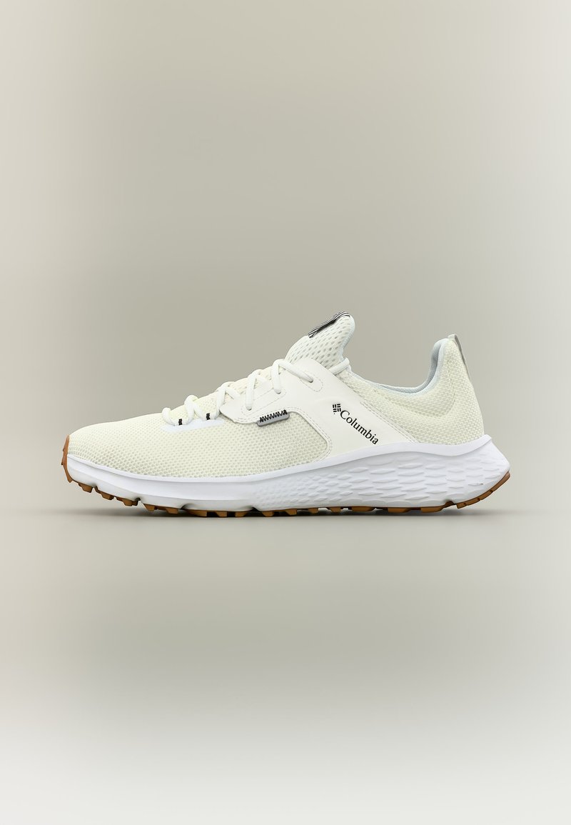Αθλητικό παπούτσι Columbia σε ανοιχτό μπεζ με επάνω μέρος από δίχτυ, λευκή υφή σόλας και καφέ πέλμα, εμφανιζόμενο σε πλαϊνή όψη σε ουδέτερο φόντο.