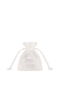 Bijela tkanina vrećica s vezicom, sa srebrnim logotipom "CHIC BY LIRETTE" i dizajnom sunčevog zraka. Glatka tekstura, kompaktni oblik.