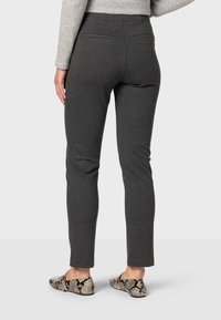 Sivé slim-fit nohavice vyrobené z mäkkej tkaniny s hladkým povrchom. Obsahujú dve zadné vrecká a sú skombinované s vzorovanými balerínkami.