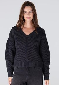 Zwarte V-hals trui met een geclusterde ribstructuur, losse mouwen en een cropped pasvorm, gemaakt van een zachte gebreide stof.