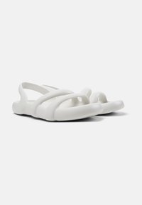 White molded sandals featuring open-toe design, wide straps, and a smooth, flexible material. The sole is slightly contoured for comfort.