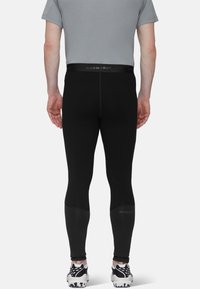 Svarta sporttights i elastiskt material, med en MAMMUT-logotyp på midjebandet och en avsmalnande design. Dolda sömmar ökar hållbarheten.