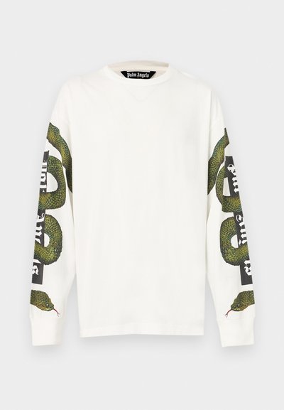 Λευκό βαμβακερό μπλουζάκι μακρυμάνικο με πράσινο γραφικό φίδι που τυλίγεται και γύρω από τα δύο μανίκια και έντονο μαύρο κείμενο στο δεξί μανίκι.