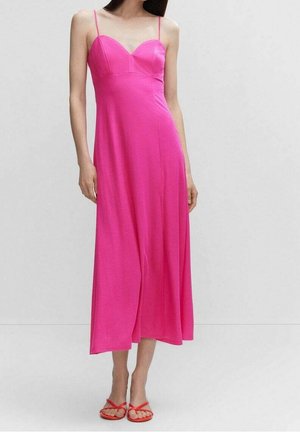 Vestido rosa sin mangas con escote corazón, corsé ajustado y falda midi fluida. Textura de tela suave, combinado con sandalias rojas.