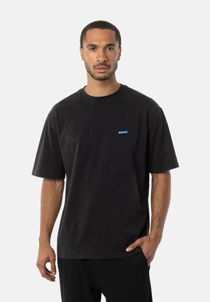 Sort bomulds t-shirt med kortærmer, rund halsudskæring og et lille blåt logo på brystet. Glat tekstur og afslappet pasform.